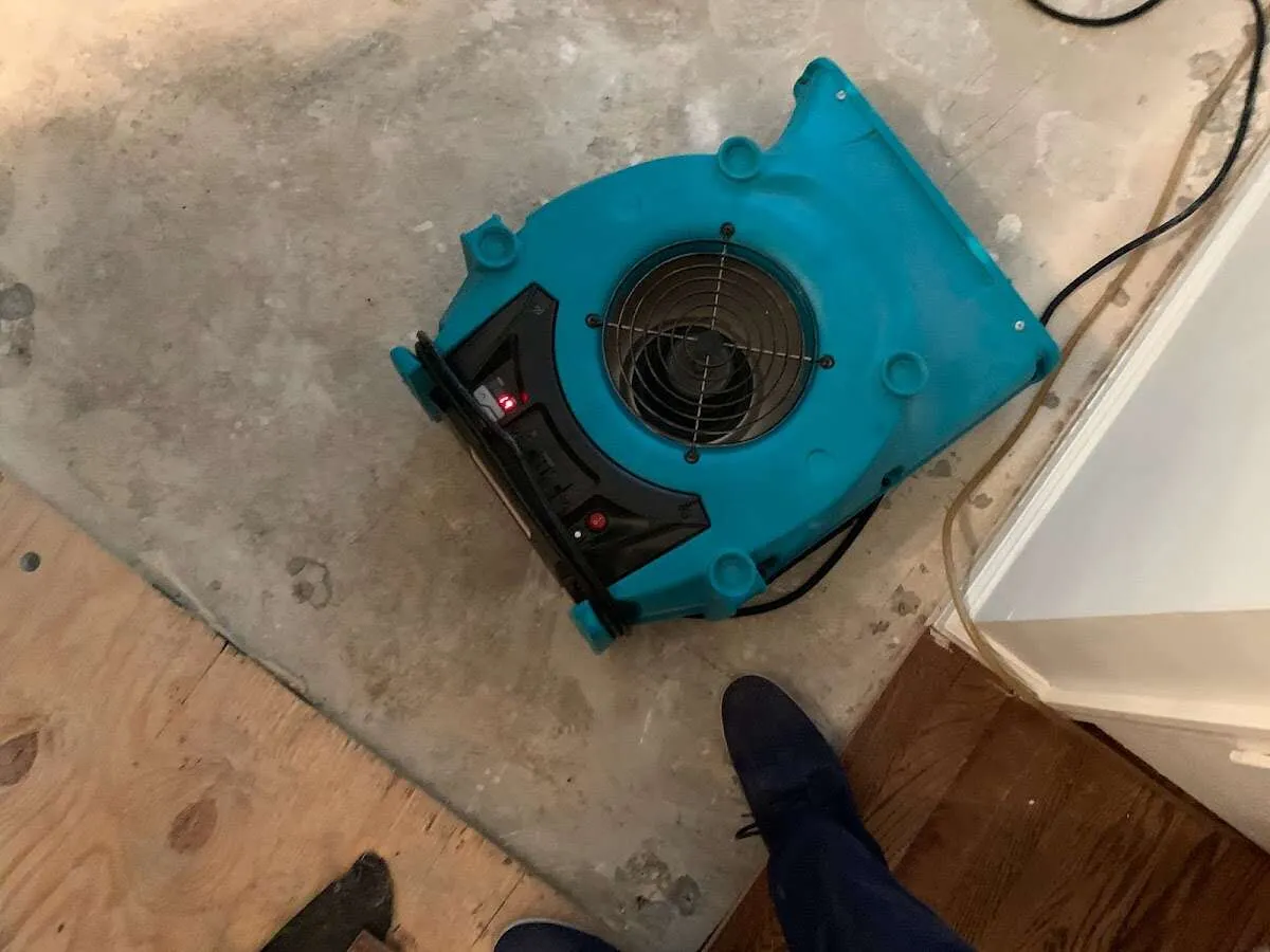 Air mover drying subfloor during Commercial Water Damage Restoration in Mound